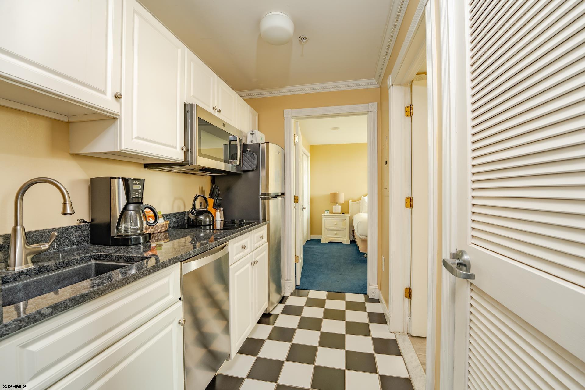 719 East 11th Street, Unit 510 Ocean City, NJ 08226 - Photo 11 of 16 a kitchen with stainless steel appliances granite countertop a refrigerator and a sink