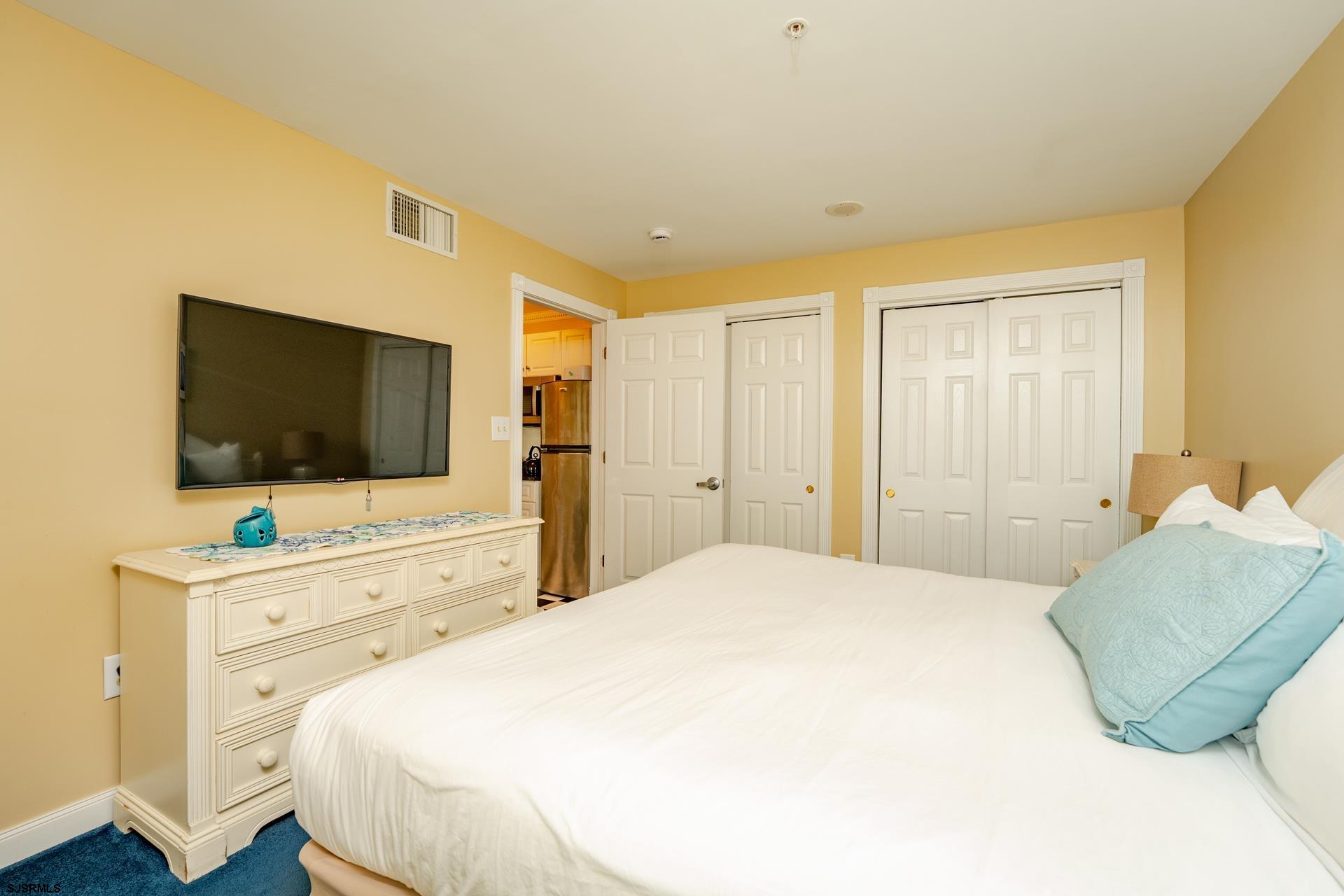 719 East 11th Street, Unit 510 Ocean City, NJ 08226 - Photo 12 of 16 a bedroom with a bed and a flat screen tv