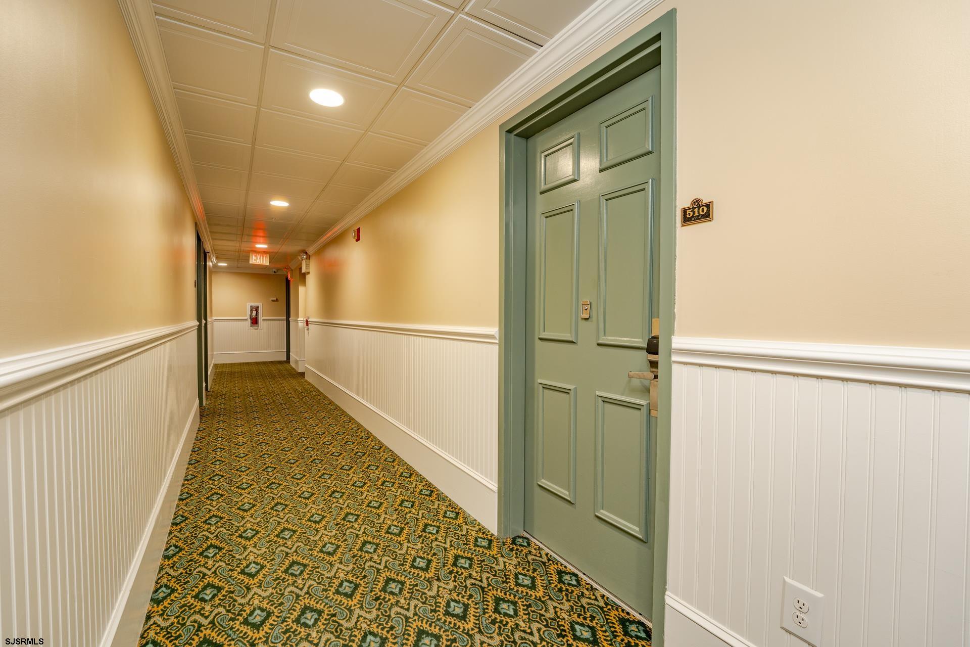 719 East 11th Street, Unit 510 Ocean City, NJ 08226 - Photo 14 of 16 a view of a hallway with wooden floor and a bathroom