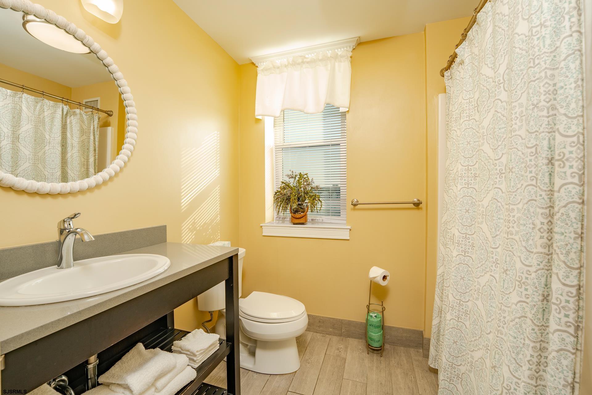 719 East 11th Street, Unit 510 Ocean City, NJ 08226 - Photo 16 of 16 a bathroom with a granite countertop sink toilet and a mirror