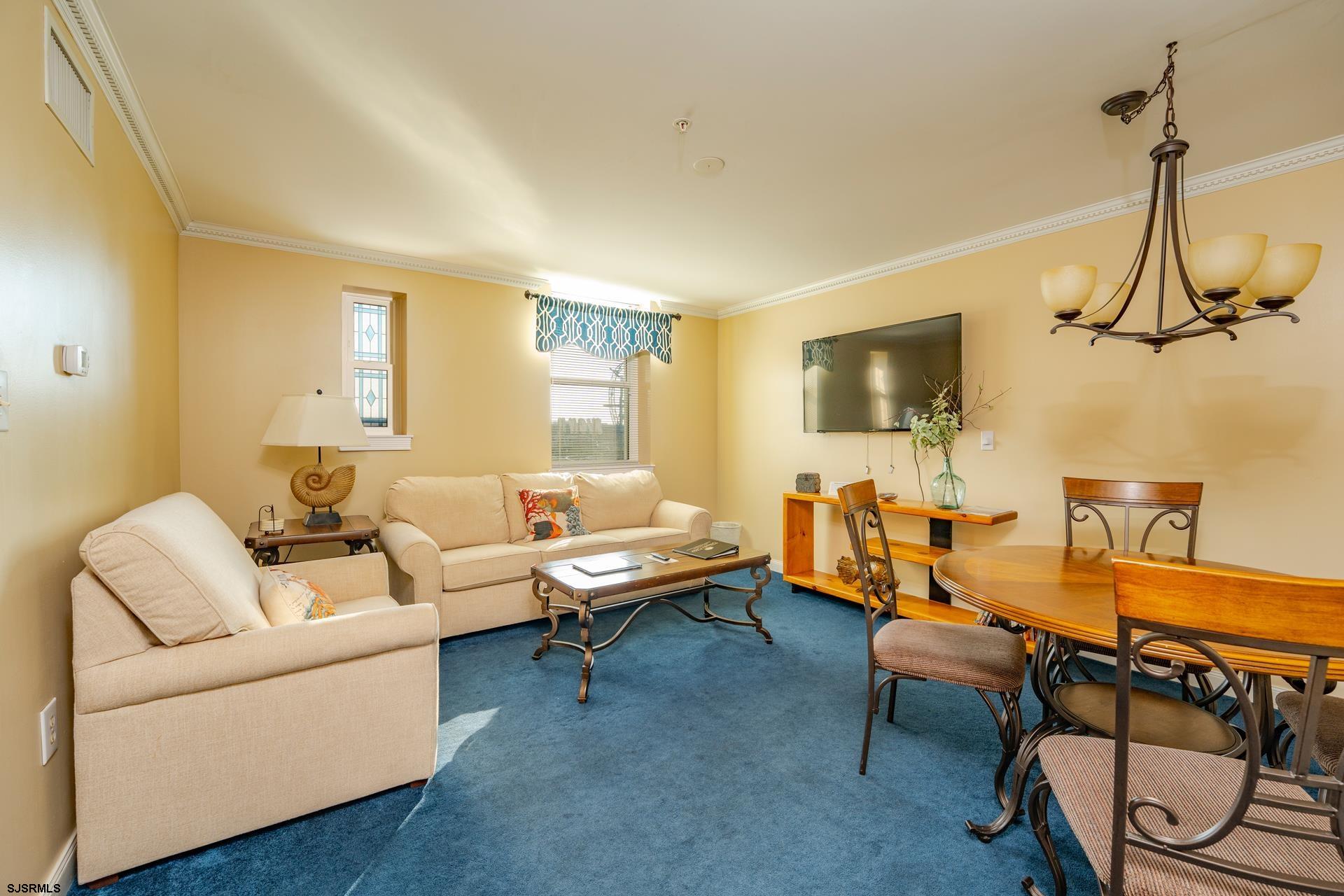 719 East 11th Street, Unit 510 Ocean City, NJ 08226 - Photo 8 of 16 a living room with furniture a flat screen tv and gym equipment