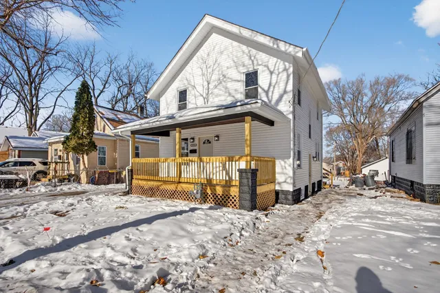 a front view of a house with a yard covered in snow