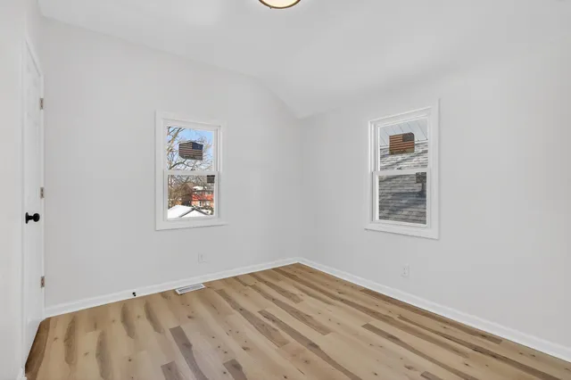 a view of empty room with wooden floor