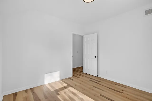 a view of a room with wooden floor and white walls