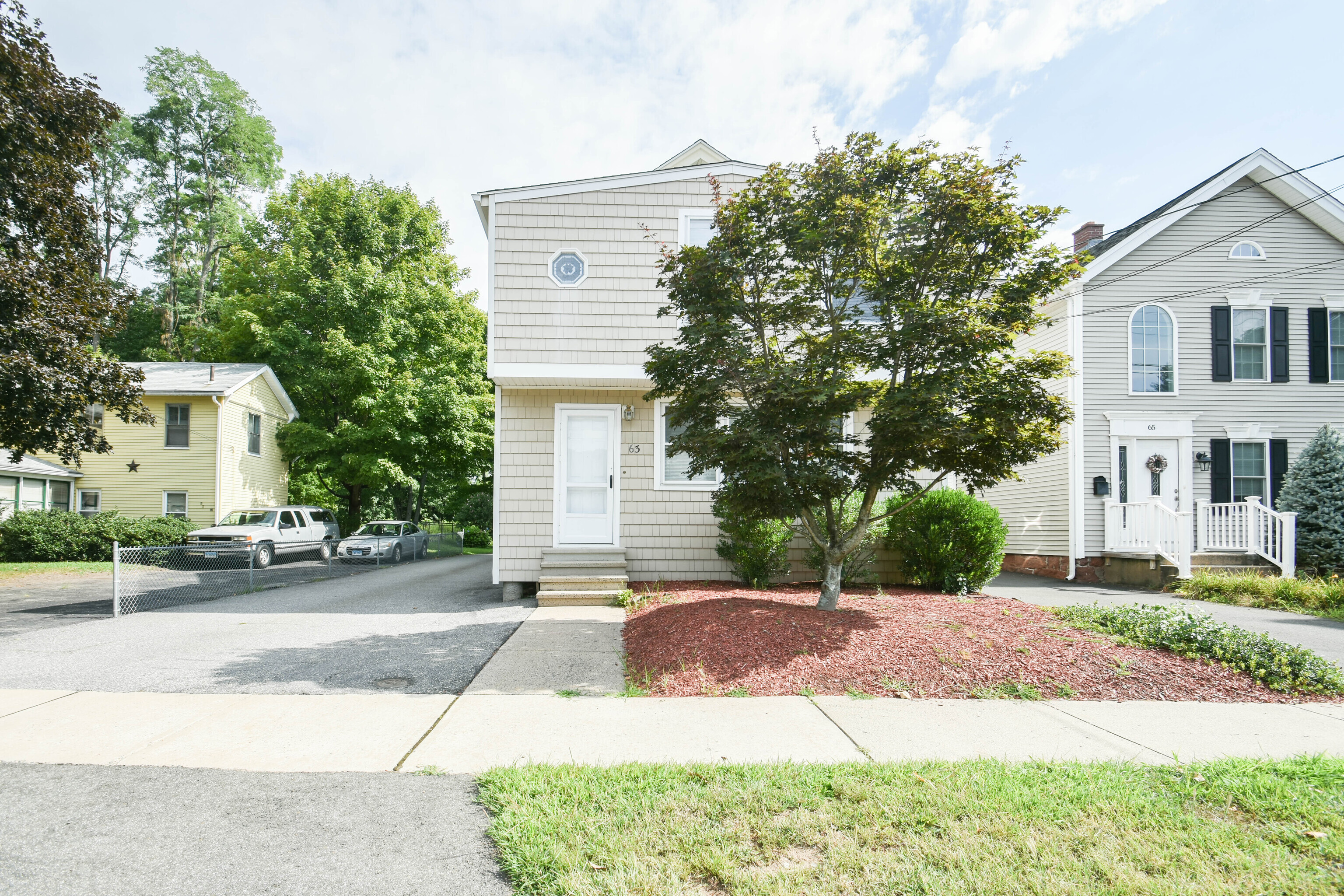 63 New Britain Avenue, Unit 1 Farmington, CT 06085 - Photo 1 of 25 a front view of a house with a yard and a garage