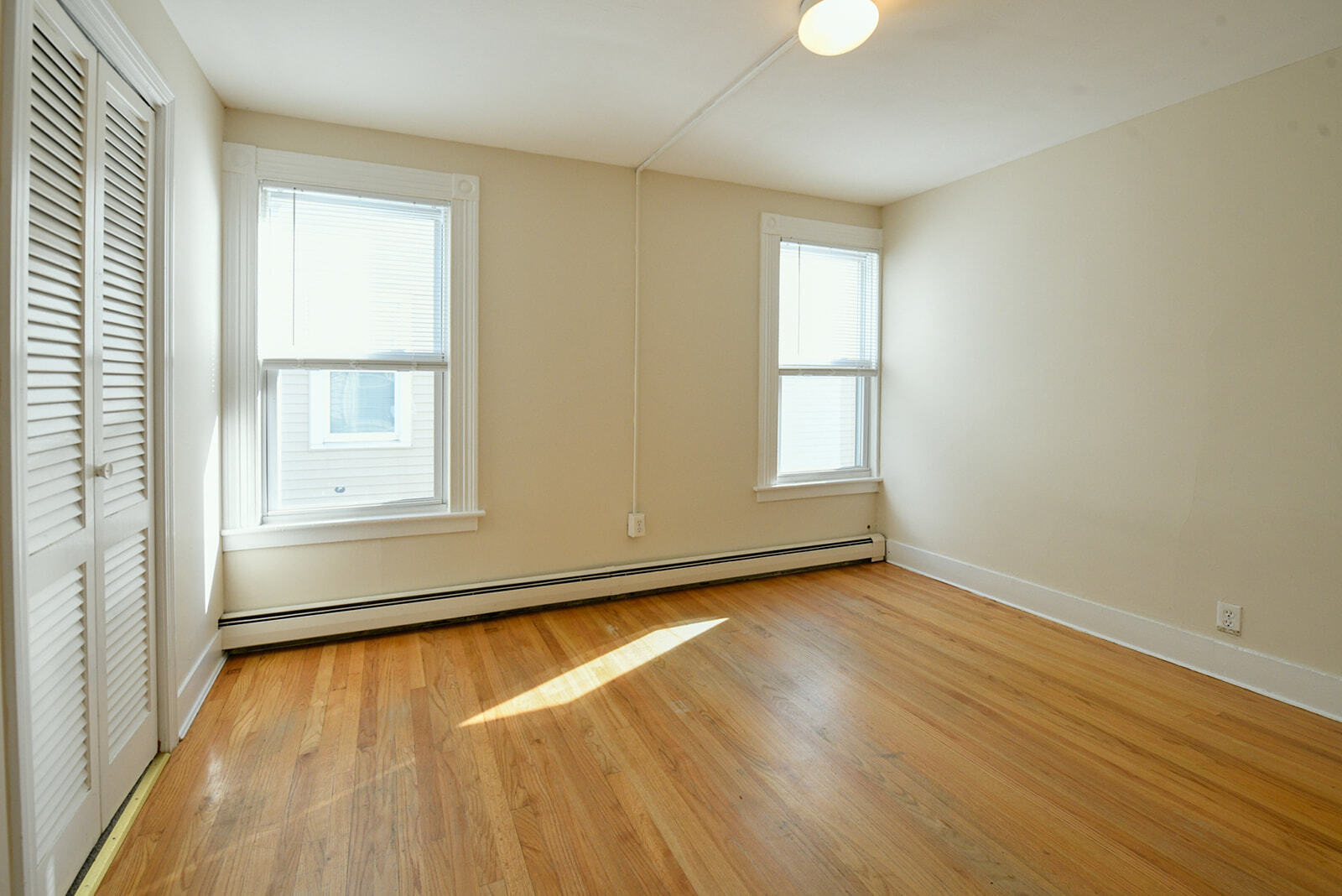 63 New Britain Avenue, Unit 1 Farmington, CT 06085 - Photo 11 of 25 an empty room with wooden floor and windows