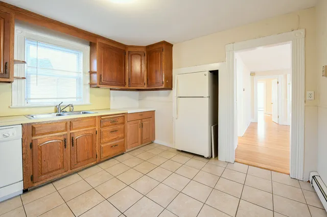 a kitchen with a refrigerator sink and cabinets