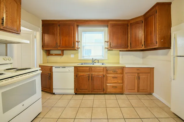 a kitchen with a stove sink and cabinets