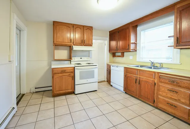 a kitchen with a stove sink and cabinets