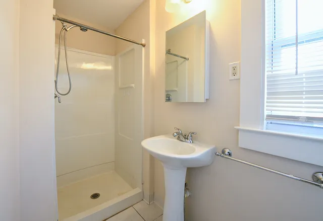 a bathroom with a shower sink and mirror