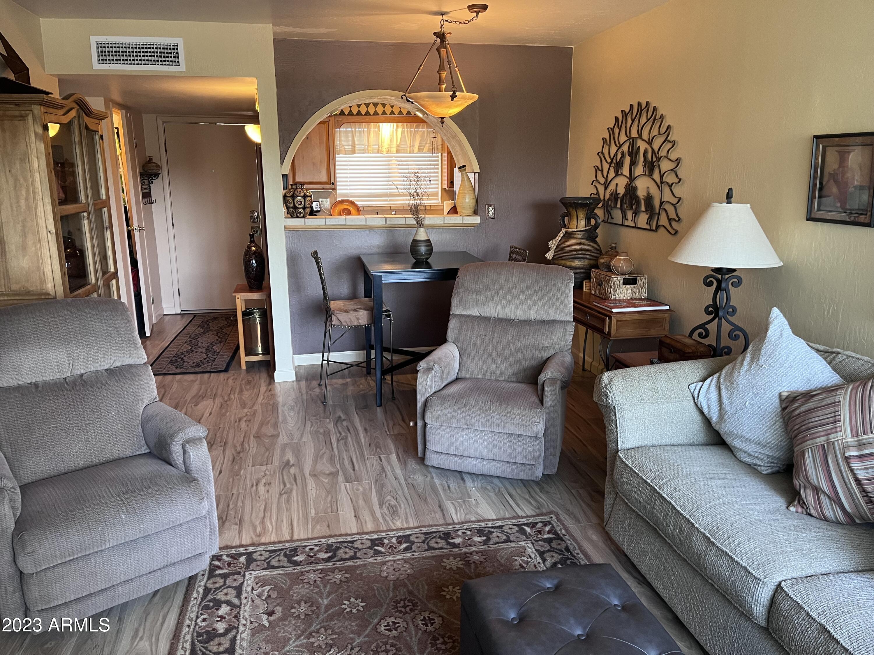4600 North 68th Street, Unit 356 Scottsdale, AZ 85251 - Photo 3 of 16 a living room with furniture and a wooden floor