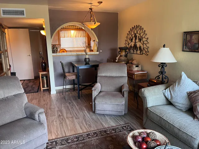 a living room with furniture a dining table and a chandelier