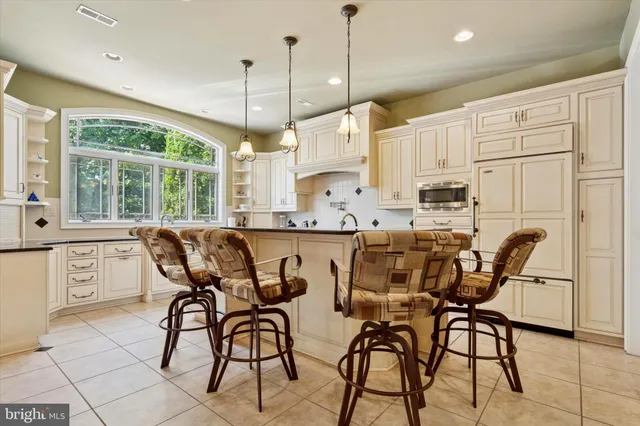 a kitchen with stainless steel appliances kitchen island granite countertop a table chairs sink and cabinets