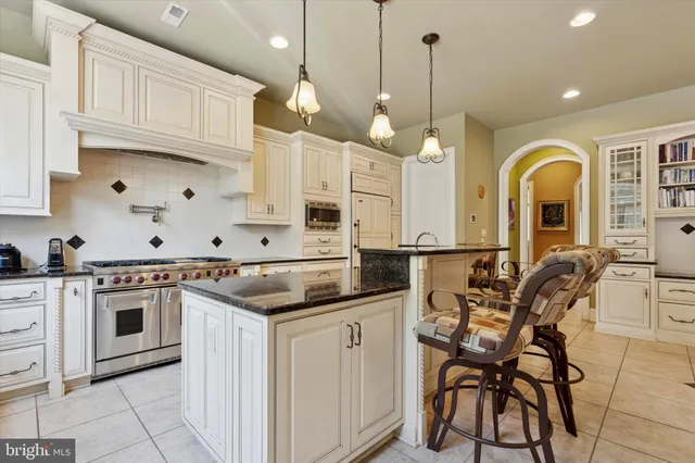 a kitchen with stainless steel appliances granite countertop a stove and white cabinets