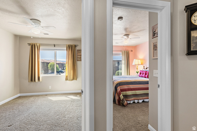 2484 Manzoni Road Santa Clara, UT 84765 - Photo 5 of 27 Bedroom featuring light colored carpet, a ceiling fan, and a textured ceiling