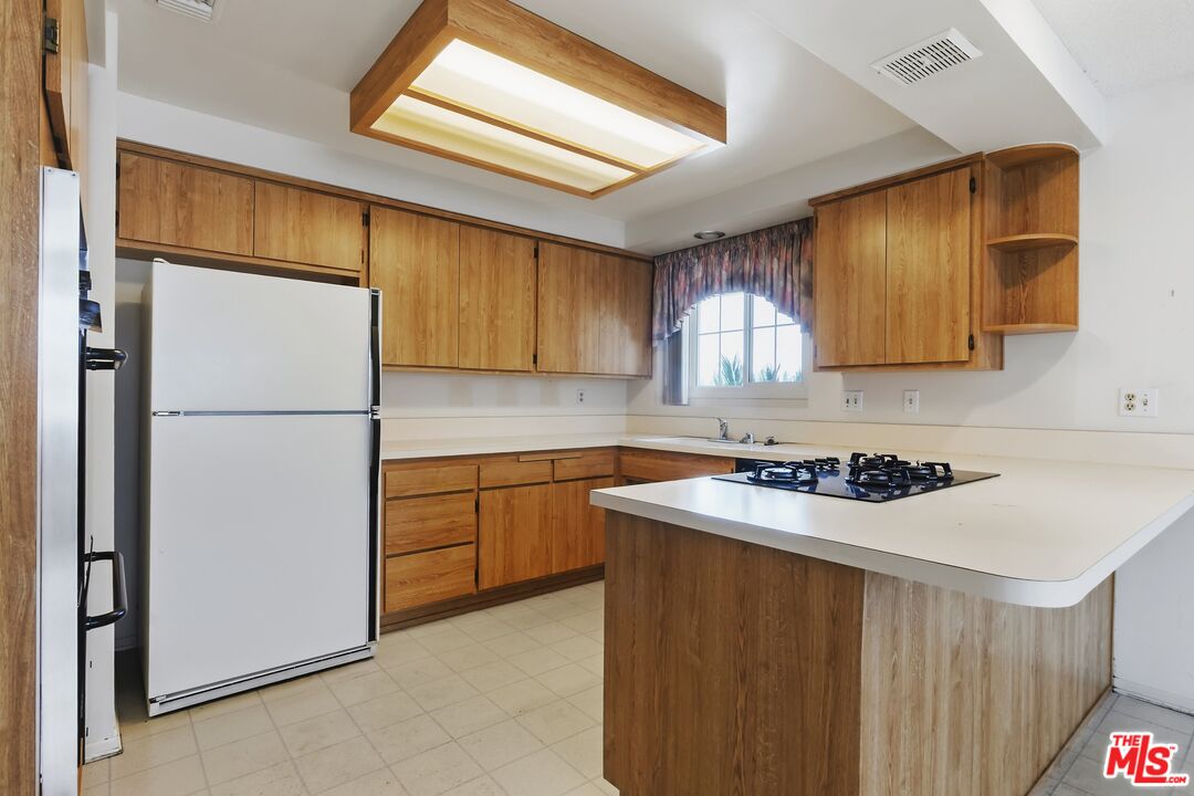 19131 Tulsa Street Porter Ranch, CA 91326 - Photo 14 of 43 a kitchen with a sink a refrigerator and cabinets