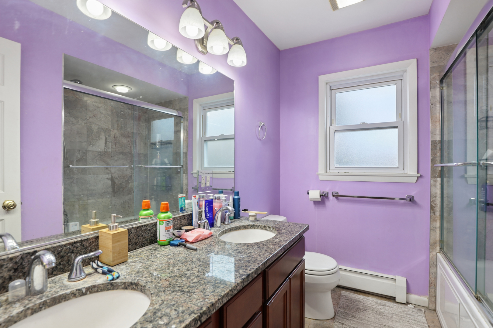 2147 Ridge Avenue, Unit 2D Evanston, IL 60201 - Photo 19 of 22 a bathroom with a granite countertop sink a toilet a mirror and vanity