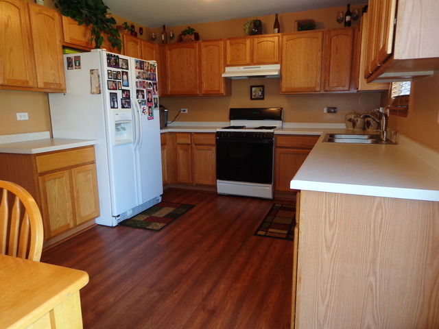 2217 Ashby Lane Plainfield, IL 60586 - Photo 7 of 20 a kitchen with stainless steel appliances granite countertop a sink a stove top oven a counter space and cabinets