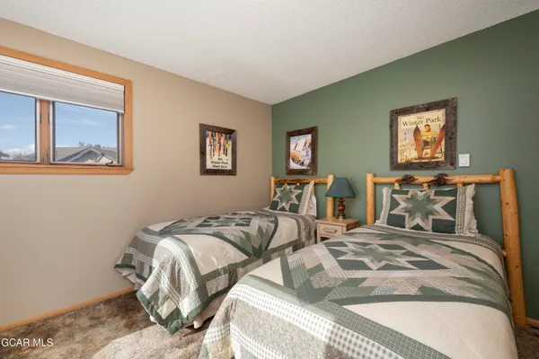 a bedroom with two beds and painting on the wall