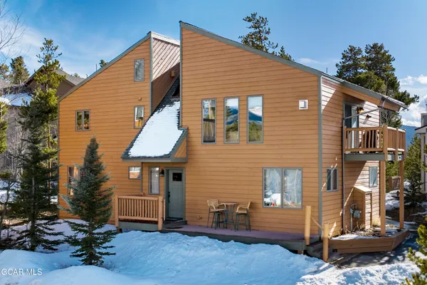 a view of a patio with table and chairs with wooden floor and fence