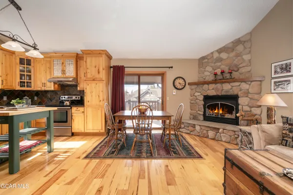 a living room with furniture a fireplace a flat screen tv and large windows