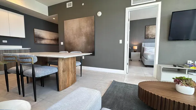 a spacious bedroom with a bed and a lamp next to a window