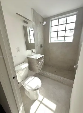 a white toilet sitting next to a bath tub a sink