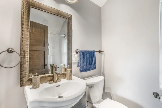 a bathroom with a toilet a sink and mirror