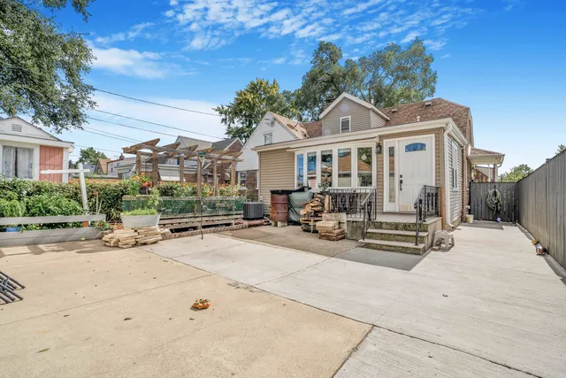 a view of a house with wooden bench in front of house