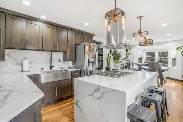 a kitchen with kitchen island granite countertop a sink appliances and cabinets
