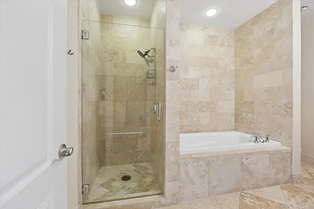 a bathroom with a granite countertop sink a mirror a bathtub and shower