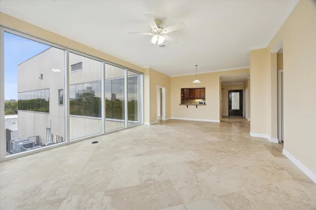 a view of an empty room with a window and a ceiling fan