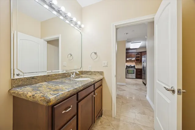 a bathroom with a granite countertop sink and a mirror
