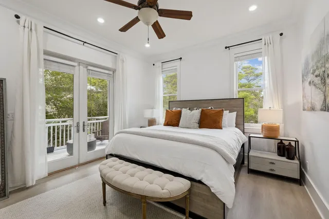 a spacious bedroom with a bed and a flat tv screen on dresser