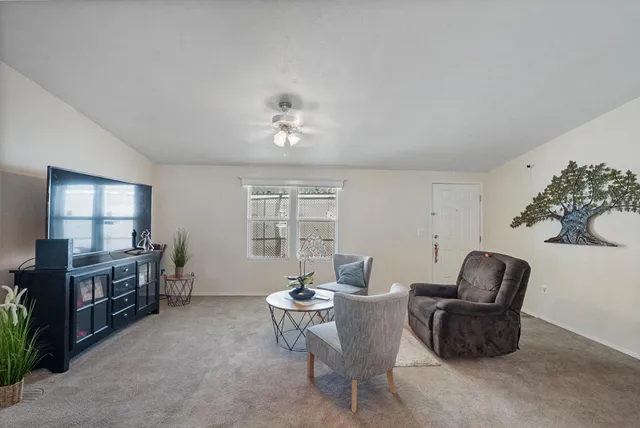 a living room with furniture a flat screen tv and a window