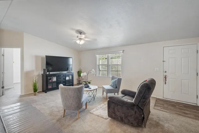 a dining room with furniture a chandelier and wooden floor