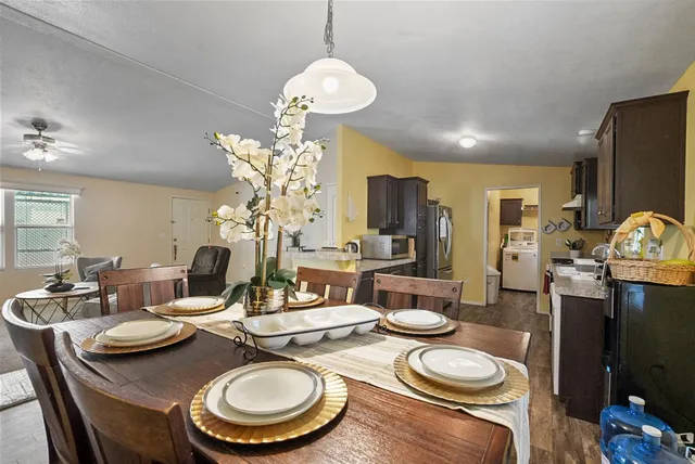 a dining room with furniture a chandelier and wooden floor
