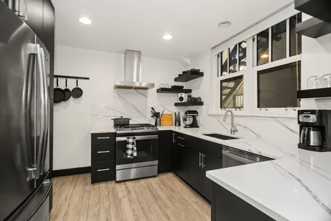 a kitchen with stainless steel appliances granite countertop a sink stove and refrigerator