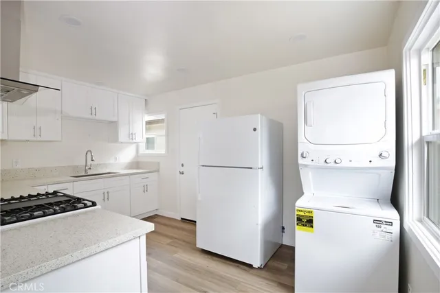 a kitchen with granite countertop a sink stove and cabinets