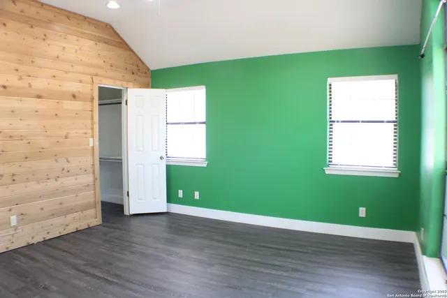 a view of a room with wooden floor and windows