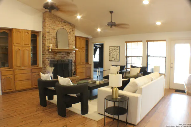 a living room with furniture a fireplace and a flat screen tv