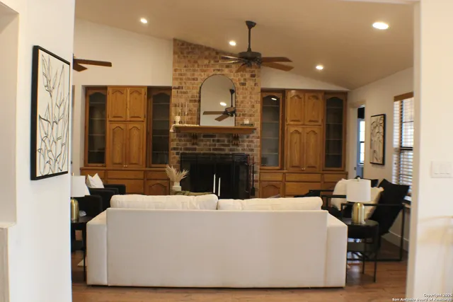 a large living room with stainless steel appliances kitchen island granite countertop furniture and a fireplace