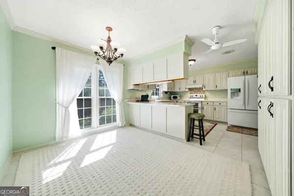 a kitchen with stainless steel appliances kitchen island granite countertop a sink cabinets and a window