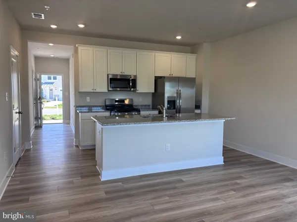 a view of kitchen with stainless steel appliances granite countertop a stove a sink a refrigerator and a microwave