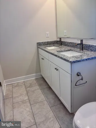 a bathroom with a granite countertop sink and toilet