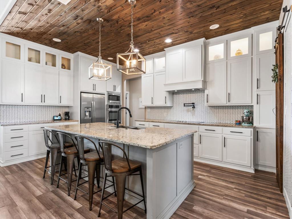 101 Trail Ridge Weatherford, TX 76087 - Photo 11 of 39 a kitchen with stainless steel appliances granite countertop a table chairs sink and cabinets