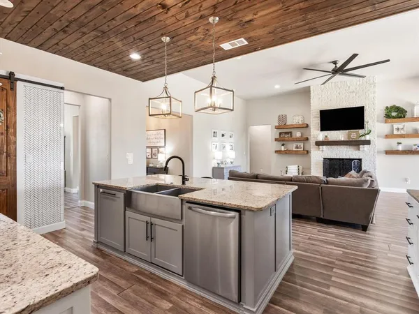 a kitchen with stainless steel appliances granite countertop a sink and a refrigerator