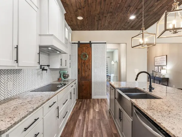 a kitchen with granite countertop a sink stove and cabinets