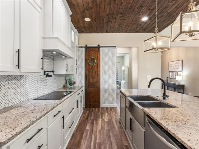 a kitchen with granite countertop a sink stove and cabinets