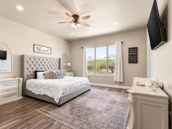 a bedroom with a large bed and a flat screen tv